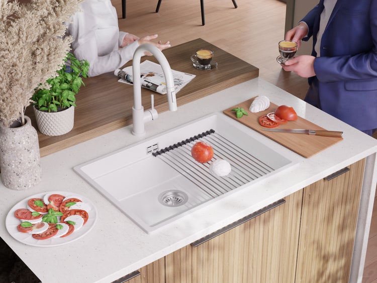 Küchenszene mit Spüle, Armatur, Abtropfgitter, Tomaten, Mozzarella und weiteren Küchenutensilien.