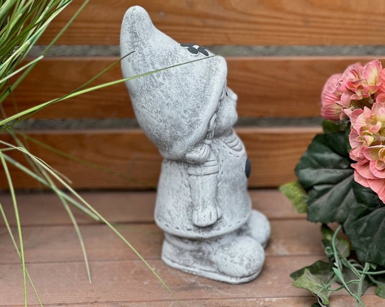 Gartenzwerg-Mädchen aus Stein in Profilansicht, dekorative Steinfigur für den Garten.
