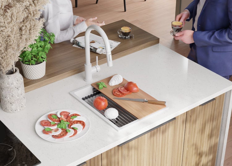 Küchenszene mit Spüle, Armatur, Schneidebrett, Tomaten, Mozzarella und Basilikum