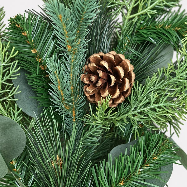 Künstlicher Weihnachtsbaumzweig mit Tannenzapfen als dekorative Winterpflanze