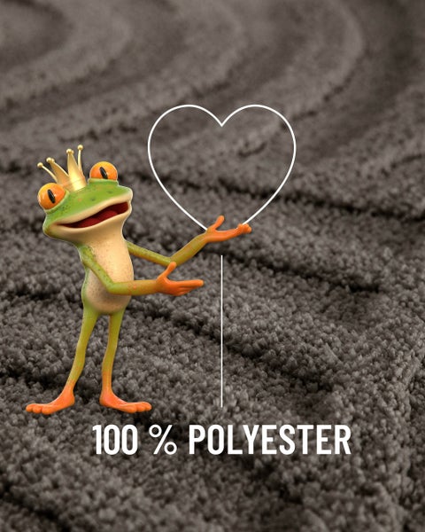 Frosch mit Krone auf Teppich weist auf Herzsymbol und Text 100 Prozent Polyester.