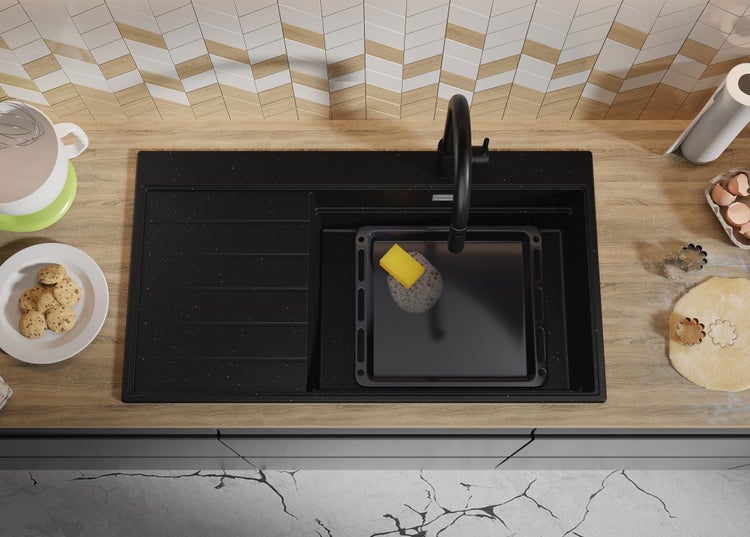 Küchenszene mit Spüle, Armatur, Backblech und Backutensilien auf einer Küchentheke