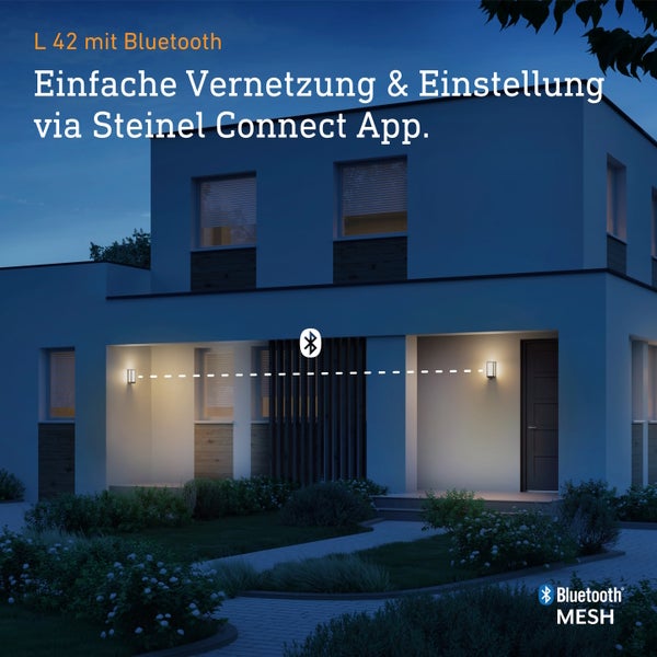 Moderne Außenwandleuchte L 42 mit Bluetooth Vernetzung und App Steuerung an einem Wohnhaus bei Nacht mit Bluetooth Mesh Technologie.