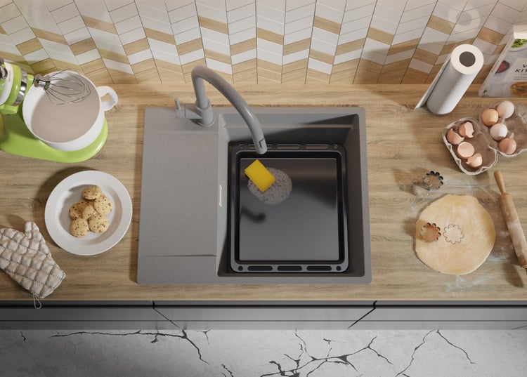 Küchenspüle mit Armatur, Backblech und Backutensilien auf einer Arbeitsplatte