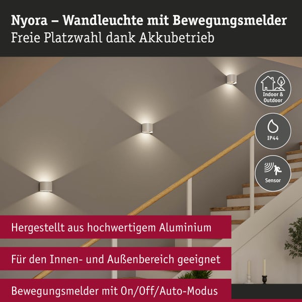 Nyora Wandleuchte mit Bewegungsmelder aus Aluminium für Innen und Außen mit Akkubetrieb montiert an einer Treppenhauswand.