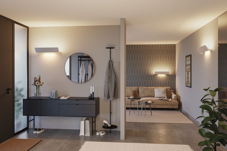 Eingangsbereich mit Garderobe, Kommode, Spiegel und Wandleuchten für eine helle und einladende Atmosphäre.