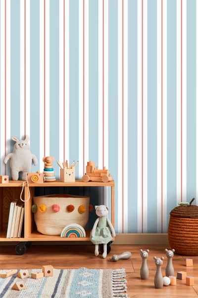 Kinderzimmer mit Spielsachen und gestreifter Tapete in hellen Farben