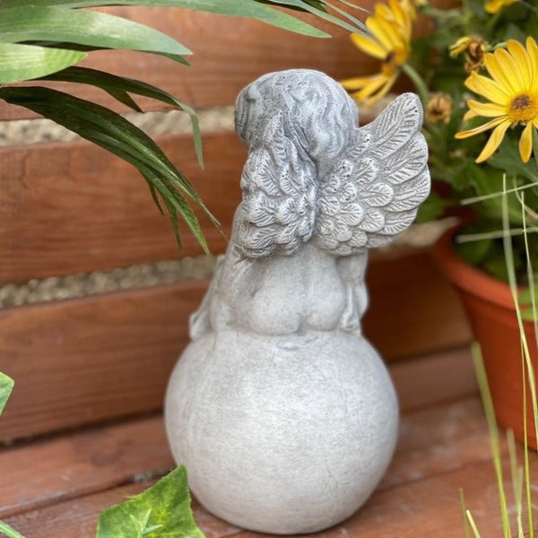 Gartenfigur Engel sitzend auf einer Kugel aus Steinguss zur Gartendekoration