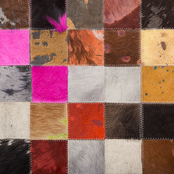 Patchwork-Teppich aus quadratischen Fellstücken mit sichtbarer Zickzack-Naht.