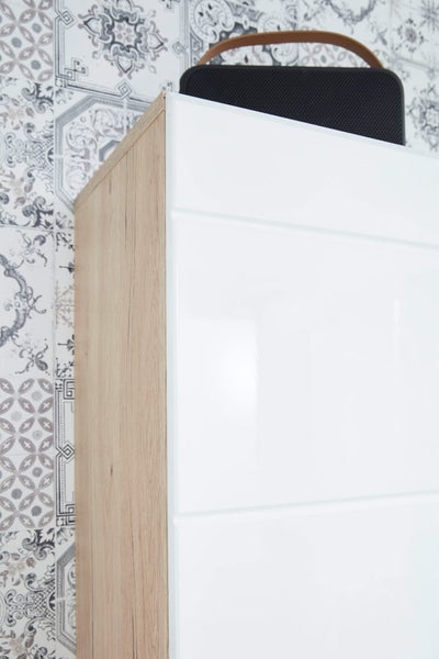 Detailaufnahme eines Schranks mit weißen Fronten und einer Seite in Holzoptik