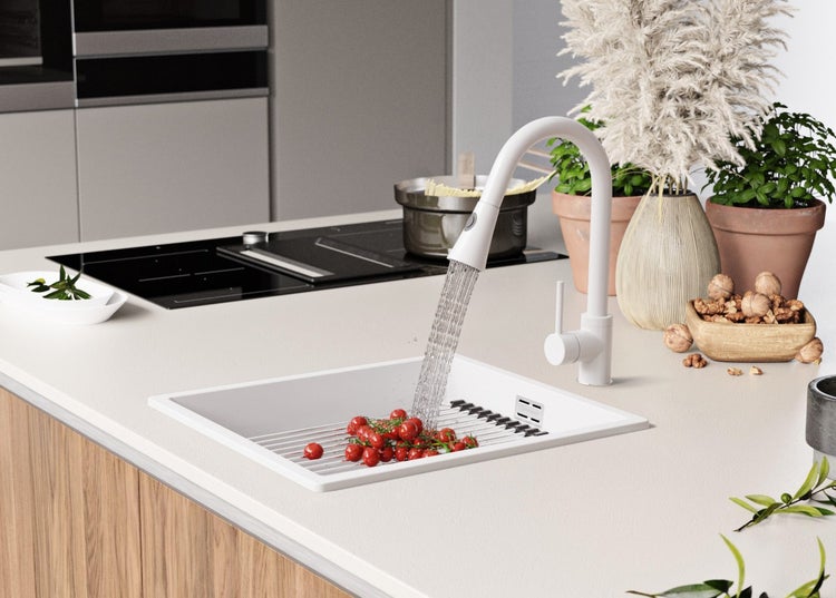 Küchenszene mit Spüle, Armatur, Lebensmitteln und Dekorationsartikeln auf einer Arbeitsplatte