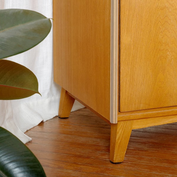 Detailaufnahme eines Holzschranks mit Beinen im Wohnbereich