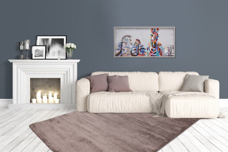 Organisiertes modernes Wohnzimmer mit weißem Sofa, lila Teppich, weißem Kaminsims und buntem Wandbild auf dunkelgrauer Wand.