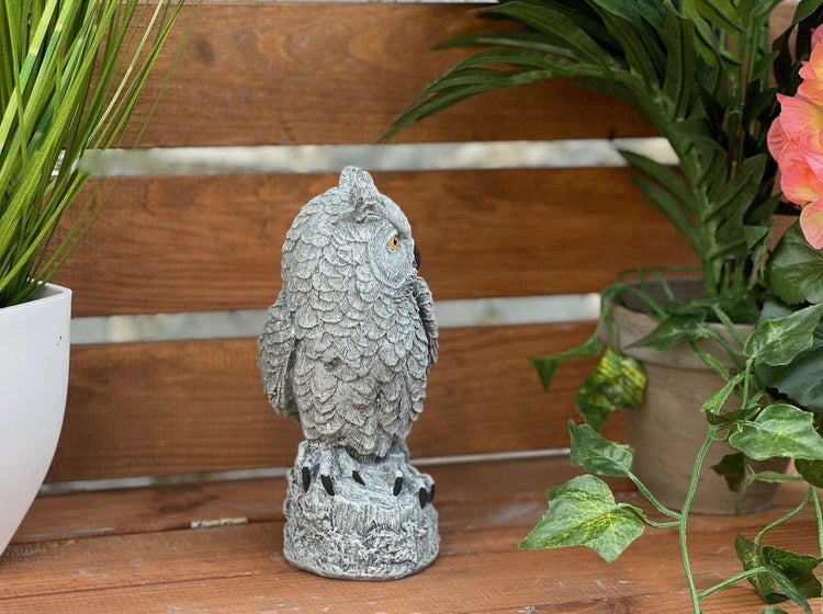 Gartenfigur Eule aus Steinoptik für die Dekoration im Außenbereich auf einem Holzuntergrund.