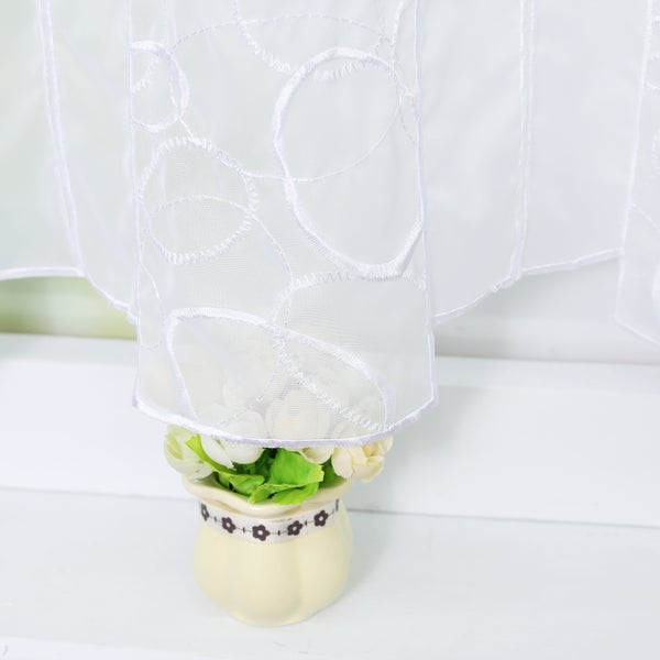 Dekorative weiße Gardine mit Blumenvase als Fensterdekoration