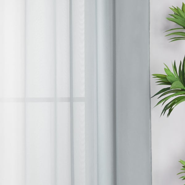Gardine vor Fenster mit Pflanze
