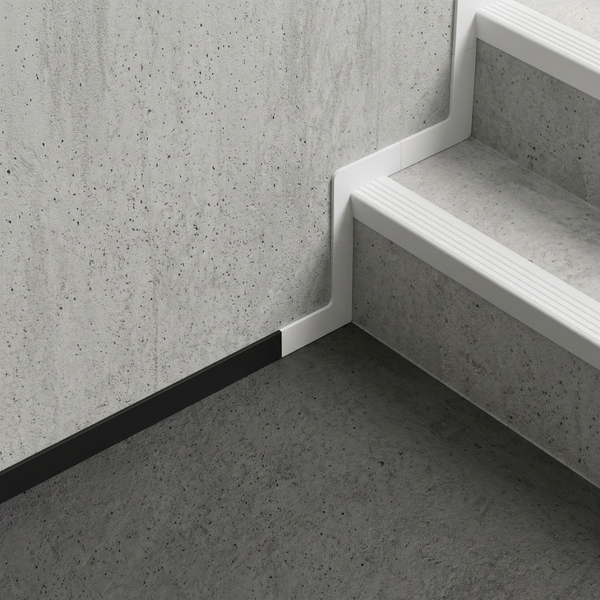 Weiße Sockelleiste und Treppenstufenprofil an einer Treppe in Betonoptik mit schwarzer Bodenleiste.