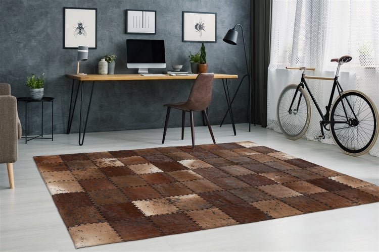 Patchwork-Teppich aus Lederquadraten in Braun und Beige in einem modern eingerichteten Arbeitszimmer mit Schreibtisch und Fahrrad.