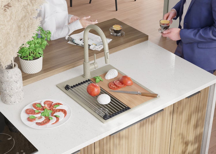 Küchenspüle mit Armatur, Schneidebrett, Tomaten, Mozzarella und fertigem Caprese-Salat