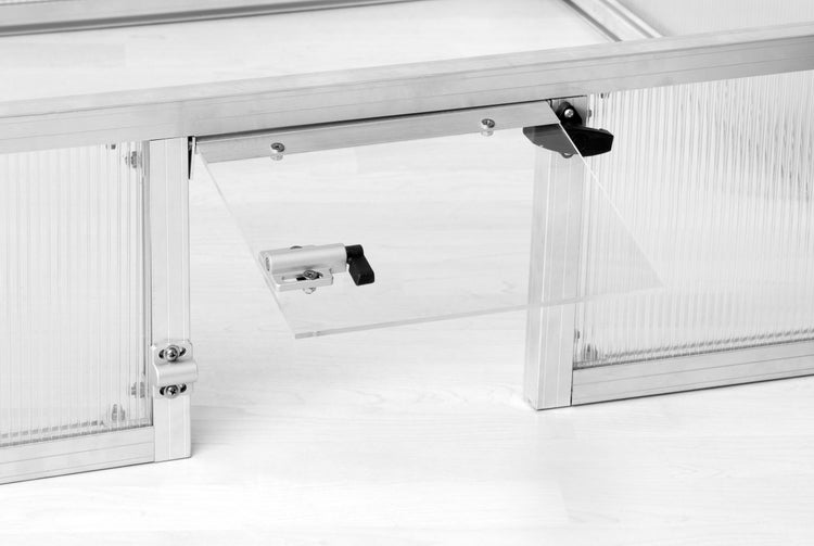Detailansicht einer Klappe für einen Kleintierstall mit Aluminiumrahmen, Hohlkammerplatte und schwarzem Verschluss.
