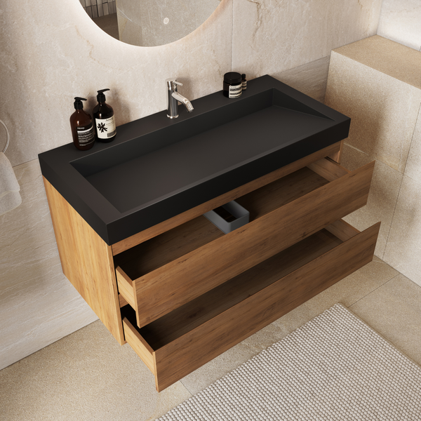 Moderner Waschtisch mit zwei Holzschubladen und mattschwarzem Waschbecken in einem hellen Badezimmer mit runden Spiegel
