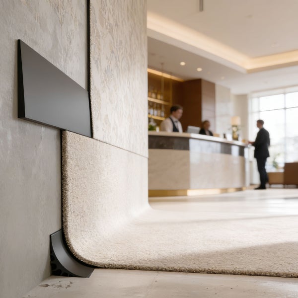 Detailansicht eines Teppichs, der an einer Wand befestigt ist, mit einer schwarzen Zierleiste