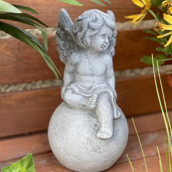 Gartenfigur Engel aus Steinguss sitzend auf einer Kugel zur Dekoration im Außenbereich