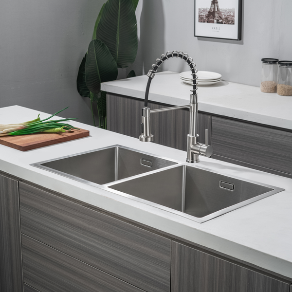 Moderne Doppelspüle aus Edelstahl mit Einhebelmischbatterie mit Federzugauslauf in einer minimalistischen Küche mit Arbeitsplatte.