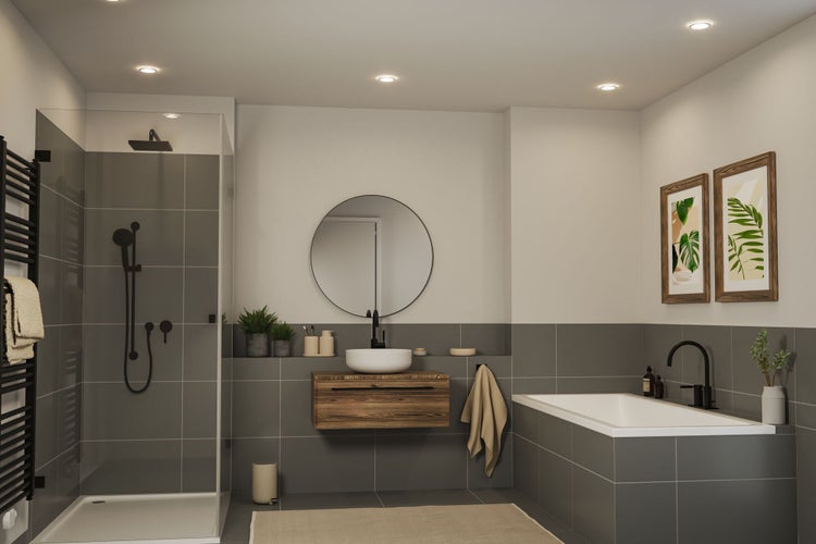 Modernes Badezimmer mit Dusche, Badewanne, wandhängendem Holzwaschtisch und rundem Spiegel. Graue Fliesen und schwarze Armaturen schaffen Akzente.