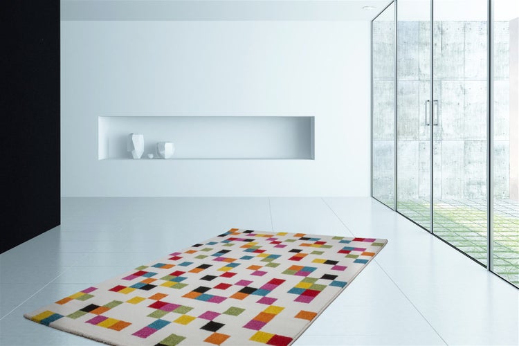 Moderner, heller Raum mit einem rechteckigen Teppich mit buntem Karomuster auf hellem Grund. Minimalistisches Interieur mit Glasfront.