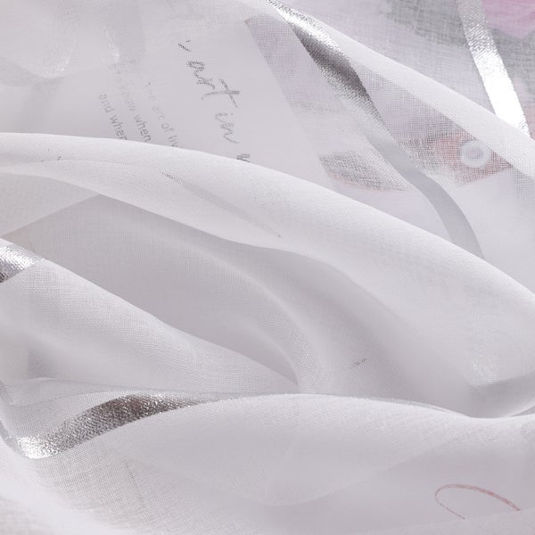 Nahaufnahme eines weißen, transparenten Dekostoffs mit silbernen Akzenten und Textdruck