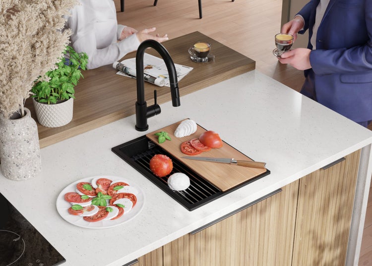 Küchenszene mit Spüle, Armatur, Schneidebrett und Zutaten für Caprese