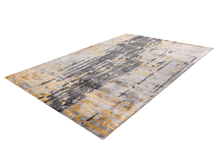 Moderner rechteckiger Teppich mit abstraktem Muster in Grau und Gold.