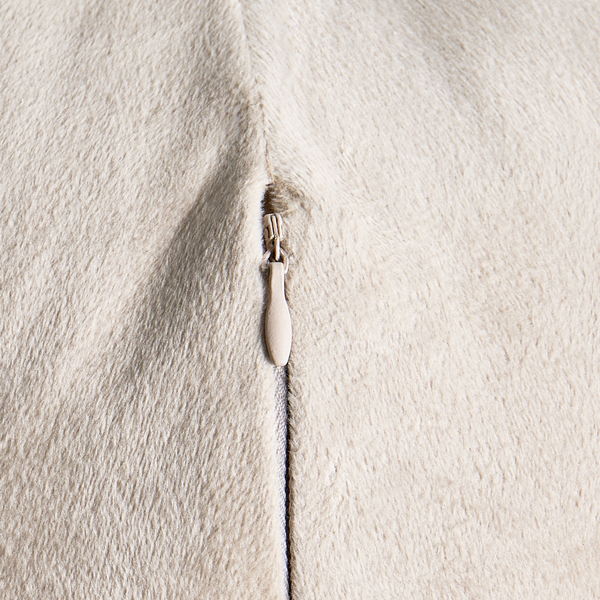 Detailansicht eines beigen Kissens mit Reißverschluss