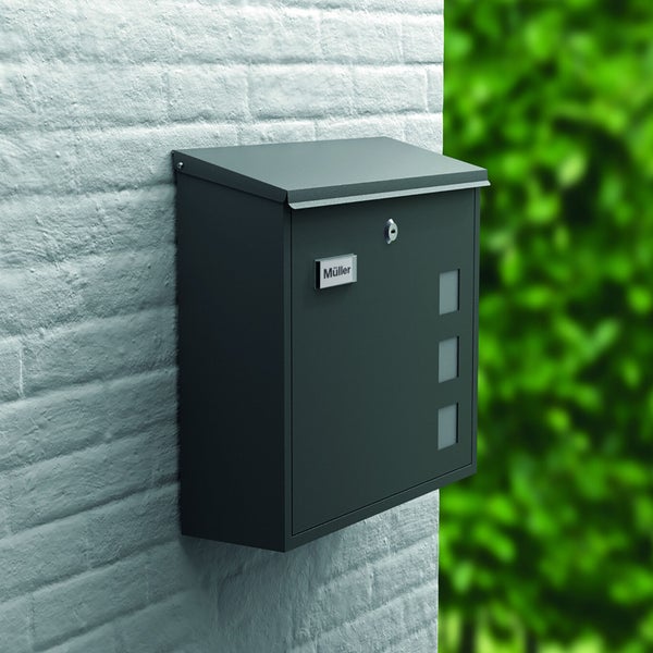 Wandbriefkasten aus Metall an einer Ziegelwand montiert, mit Namensschild, Schloss und drei Sichtfenstern.