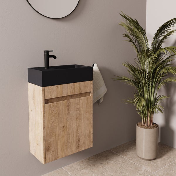Wandhängender Waschtischunterschrank mit Holzoptik Front und schwarzem Waschbecken sowie schwarzer Armatur in modernem Badezimmer.
