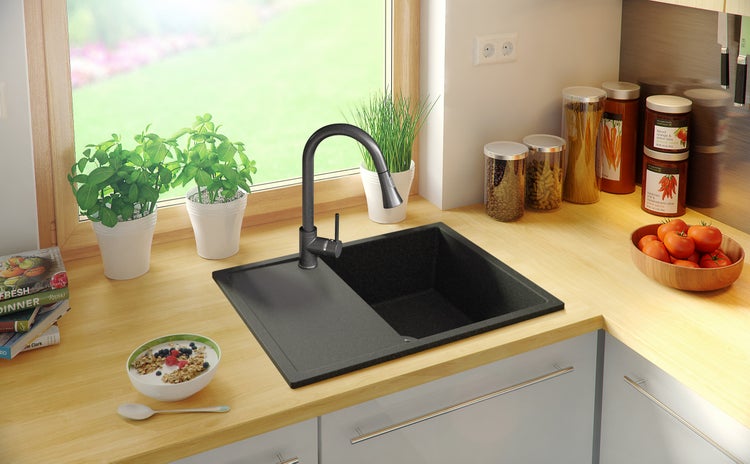 Küchenspüle mit Abtropffläche und Wasserhahn in einer hellen Küche.