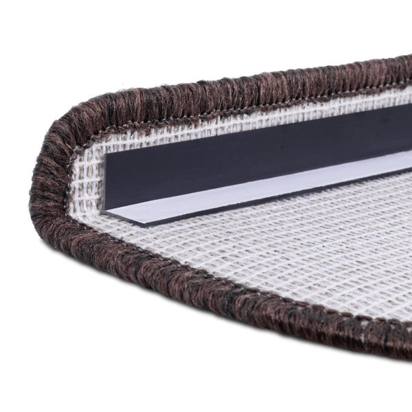Detailansicht einer Treppenstufe mit braunem Teppich und Befestigungsstreifen