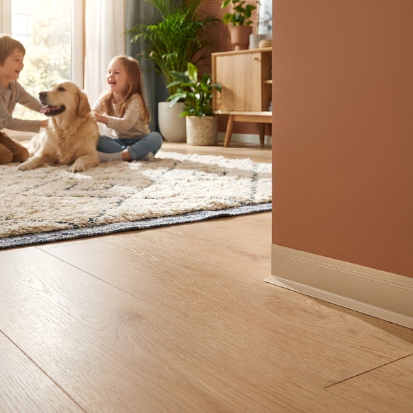 Heller Holzboden in einem Wohnzimmer, mit spielenden Kindern und einem Hund im Hintergrund