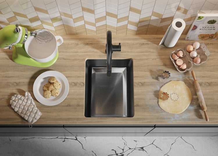 Küchenszene mit Spüle, Armatur, Küchenmaschine, Kochbuch, Eiern, Plätzchenteig und gebackenen Keksen