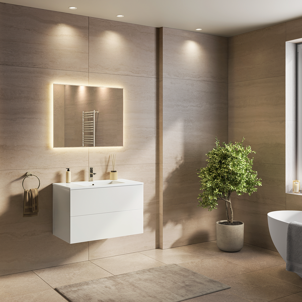 Modernes Badezimmer mit weißem Waschtischunterschrank, beleuchtetem Wandspiegel, freistehender Badewanne und großformatigen Wandfliesen.