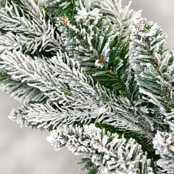 Detailansicht eines künstlichen Tannenzweigs mit künstlicher Schnee-Beschichtung für Weihnachtsdekoration