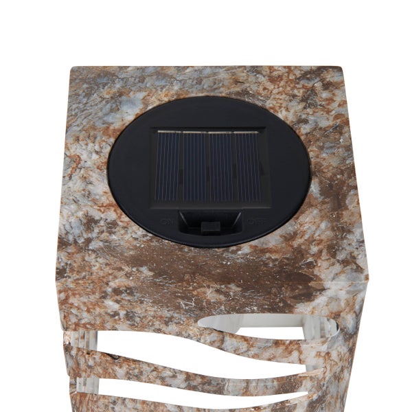 Dekorative Lampe aus Holz mit Blumenstrauß auf einem Gartentisch.