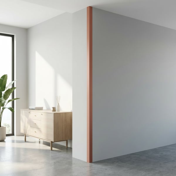 Moderne Wohnraumecke mit einer hellen Wand, einer Holzkommode und einem dekorativen Akzentstreifen an der Wandkante.