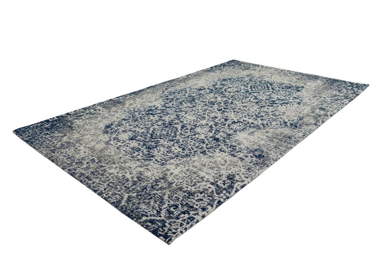 Rechteckiger Teppich mit verwaschenem Vintage-Orientmuster in Blau und Weiß.