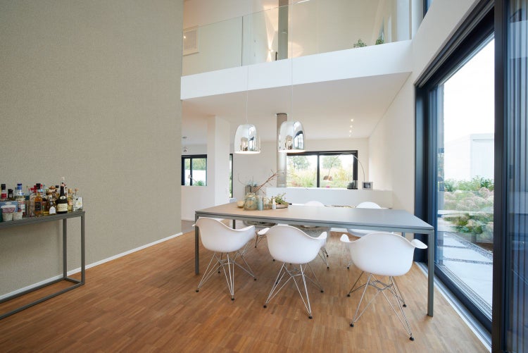 Kinderzimmer mit weißem Sideboard und Deko-Elementen vor einer Tapete mit Tiermotiven