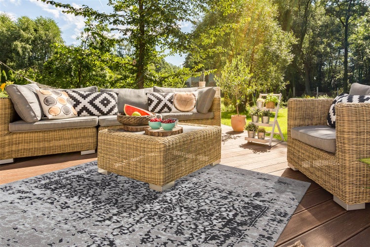 Rechteckiger Teppich mit verwaschenem Vintage-Orientmuster in Grau und Schwarz.