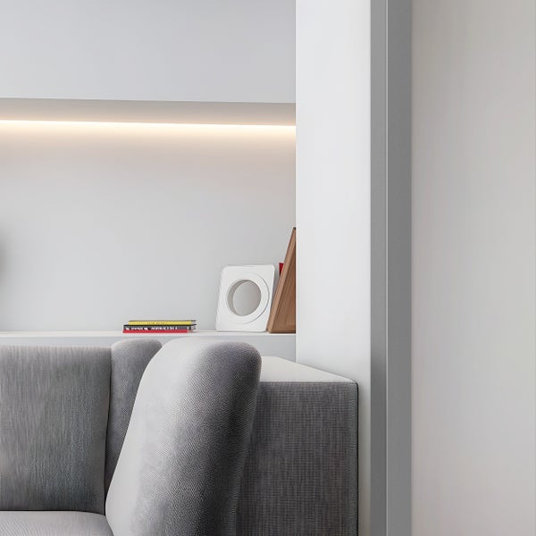 Detailaufnahme eines Wohnzimmers mit grauer Couch, Bücherregal und Dekorationsgegenständen