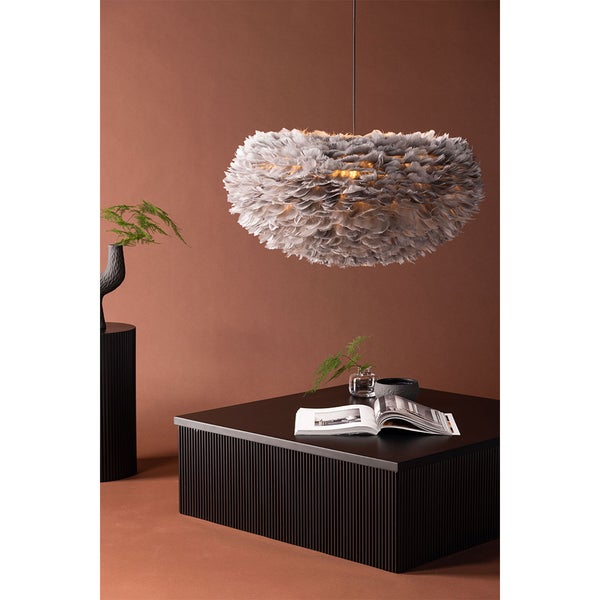 Dekoratives Zimmer mit Federlampe, Tisch und Pflanzendekoration