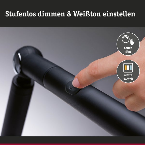 Schreibtisch mit LED-Lampe und aufgeschlagenem Buch